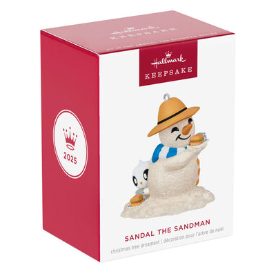 Hallmark Keepsake Sandal the Sandman ornament—sand snowman in Bermuda hat, blue and white scarf, with sub sandwich and sea turtle friend on the beach
