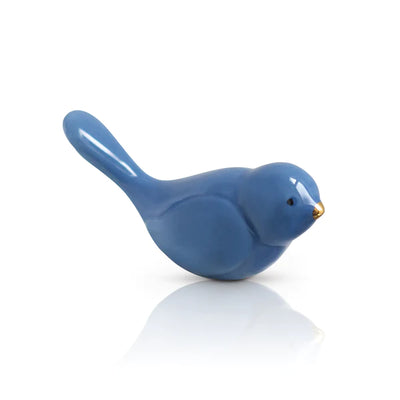 Blue ceramic bird figurine with gold beak on white surface
