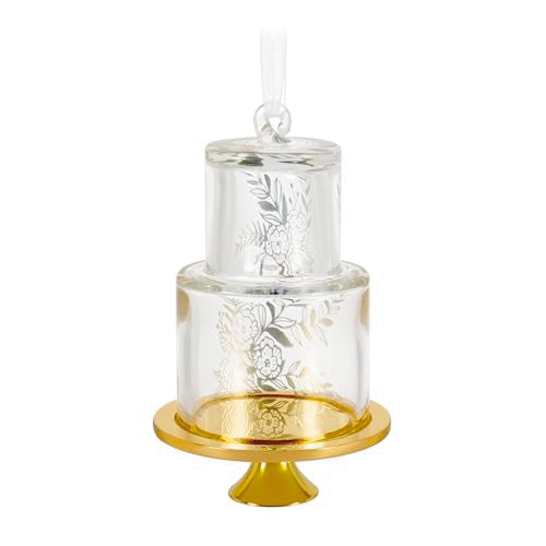 Glass wedding cake ornament with gold leaf and floral accents on clear tiers, featuring “2025” and gold base for newlywed Christmas keepsake.