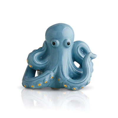 Tiny blue octopus figurine on a white table.