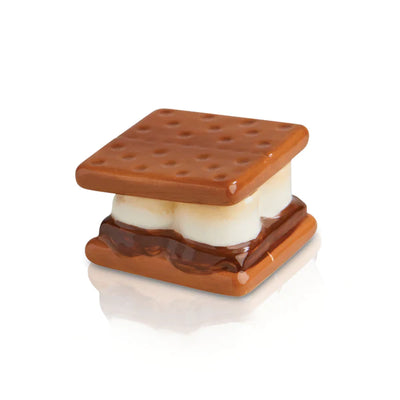 Close-up photo of a s'more with toasted marshmallow, chocolate bar, and graham cracker halves.