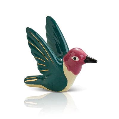 Ceramic hummingbird figurine perched on a table