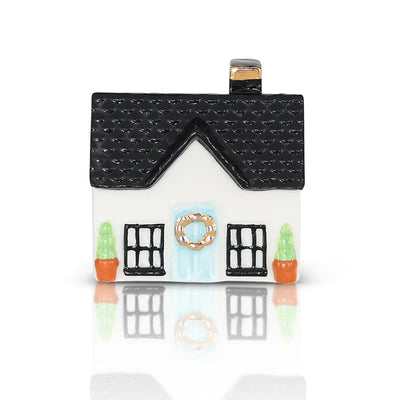 Small white house with black roof and wreath on front door