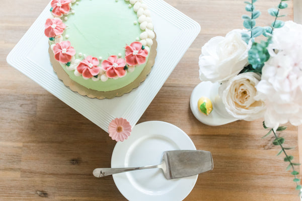 White pinstripe square cake pedestal, 13 inches wide, dishwasher and microwave safe, from Nora Fleming collection.

