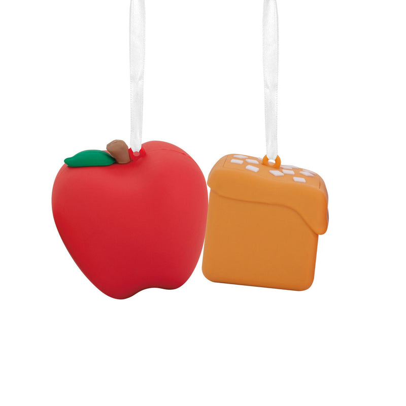 Two Hallmark magnetic Christmas ornaments: a red apple and a slice of bread with a smiley face. 