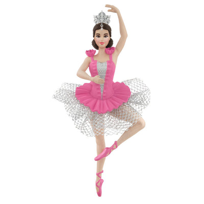 Barbie ballerina Christmas ornament wearing a pink tutu, pointe shoes, and silver tiara, posed en pointe with arm raised in a graceful ballet position.