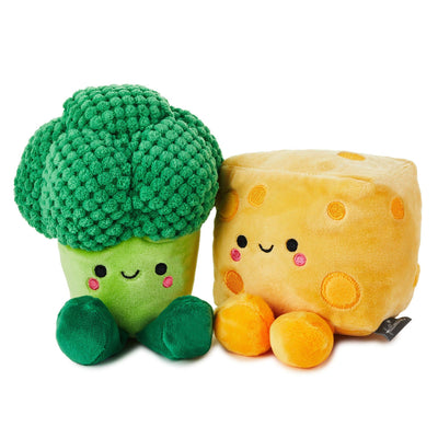 Stuffed broccoli and cheese plush toy sitting side-by-side. The broccoli is green and the cheese is yellow.