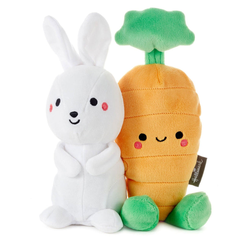 White rabbit and carrot plush toys on white background