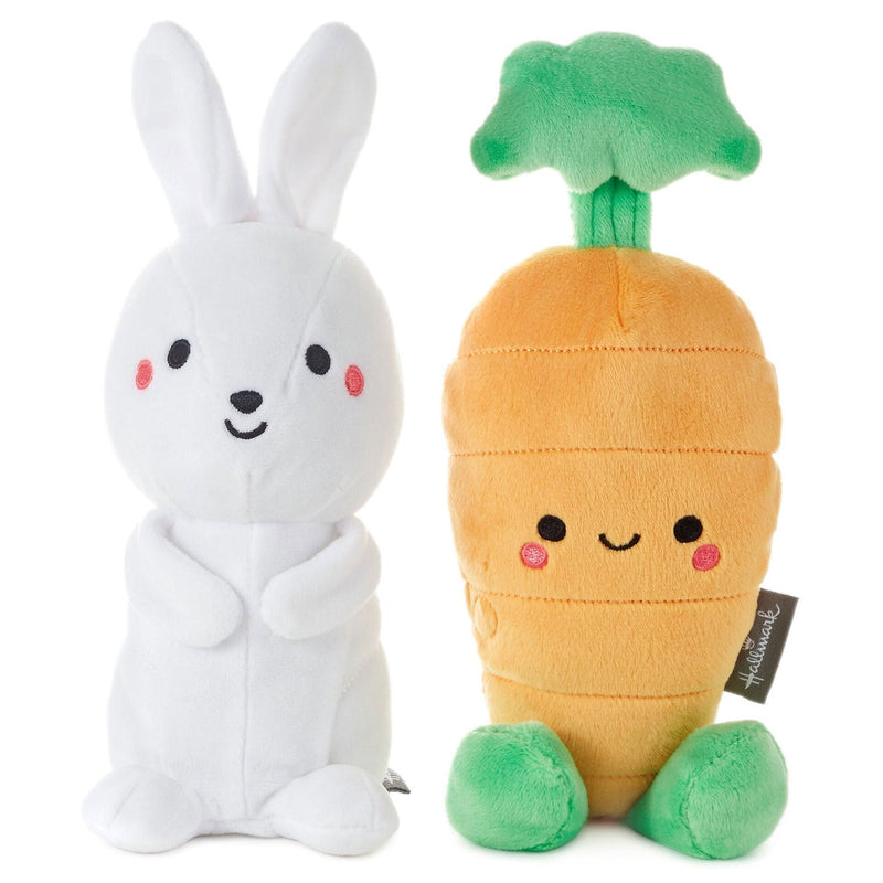White rabbit and carrot plush toys on white background