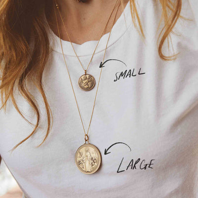 Gold coin pendant necklace. This necklace features two gold coins, one large and one small, hanging from a delicate chain.