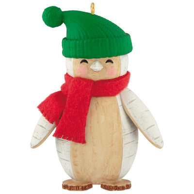 Penguin Christmas ornament styled like birch wood, wearing red scarf and green stocking hat