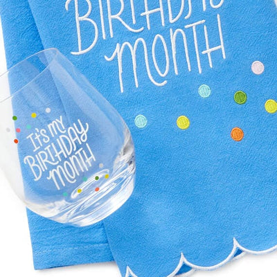 Hallmark birthday month gift set with blue embroidered tea towel and coordinating stemless wine glass, perfect for milestone 
