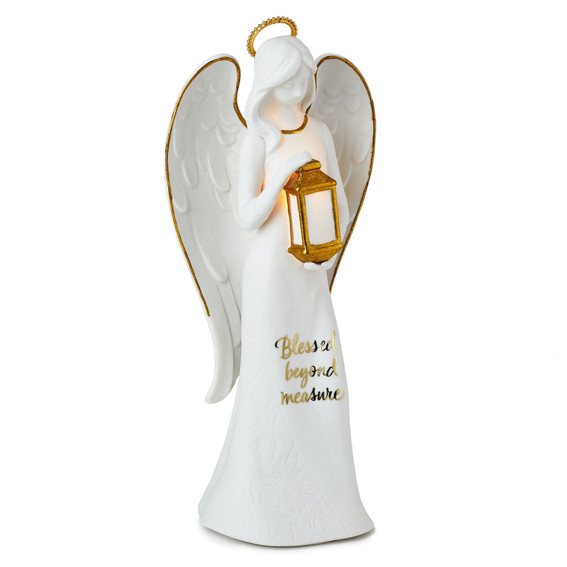 Tall ceramic angel figurine with light-up lantern, gold accents, and Blessed beyond measure inscription.

