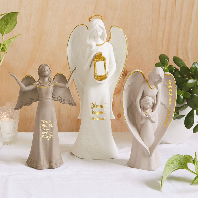 Tall ceramic angel figurine with light-up lantern, gold accents, and Blessed beyond measure inscription.
