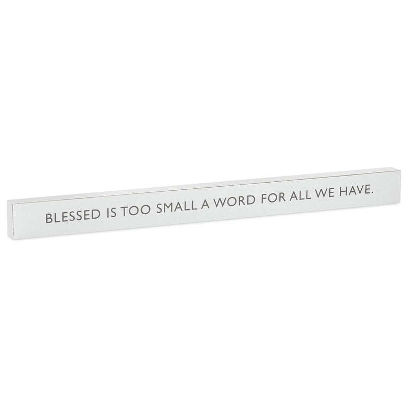 Hallmark white wood quote sign with gray text: “Blessed is too small a word for all we have.”