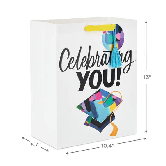 Hallmark large graduation gift bag with colorful mortarboard, black lettering on white, gift tag, and tassel attachment.


