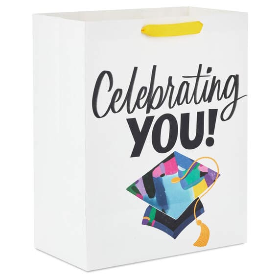 Hallmark large graduation gift bag with colorful mortarboard, black lettering on white, gift tag, and tassel attachment.

