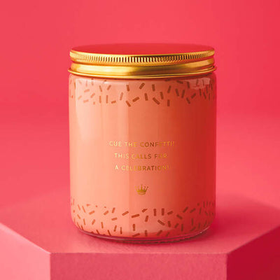 Festive Hallmark single-wick candle with orange and pear scent, coral confetti design, and “Congrats!” message.

