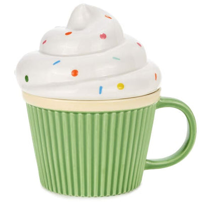 Green cupcake with white frosting and rainbow sprinkles