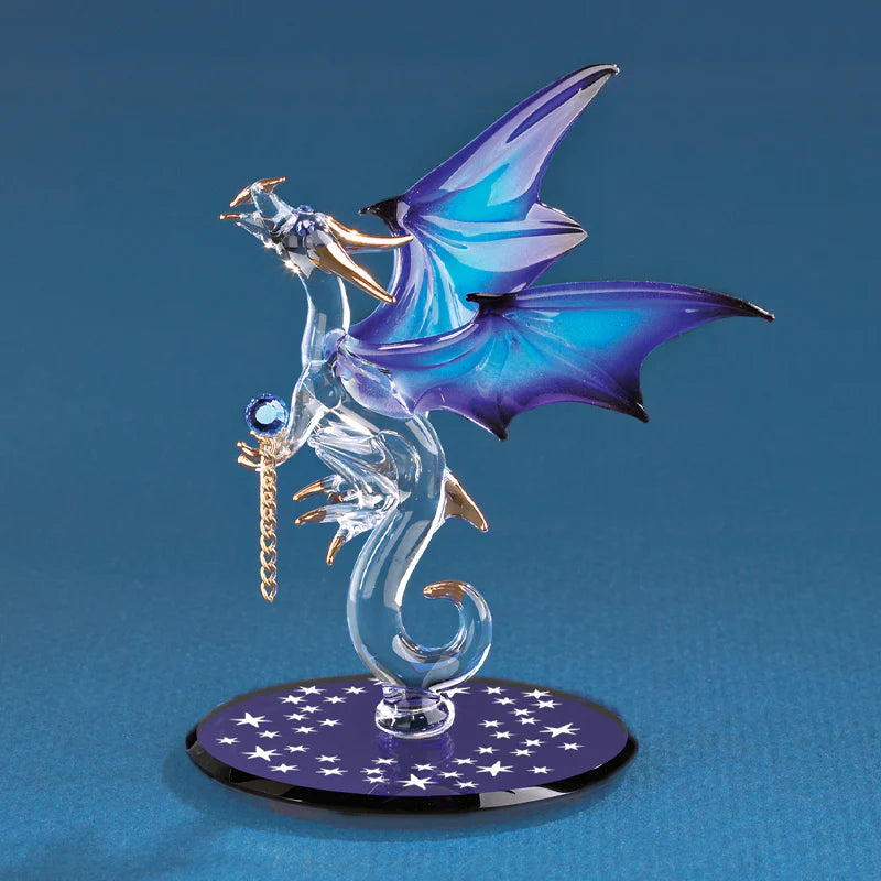 blue wings holding a blue gem, placed on a blue beveled glass mirror and accented with crystals, 22Kt gold, and air brushing.
