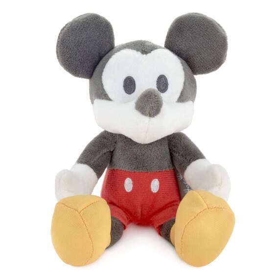 stuffed Mickey Mouse plush holding a gift card with a red background with white snowflakes. The text on the gift card reads ”FOR THE PERFECT GIFT (CARD) OR MONEY
