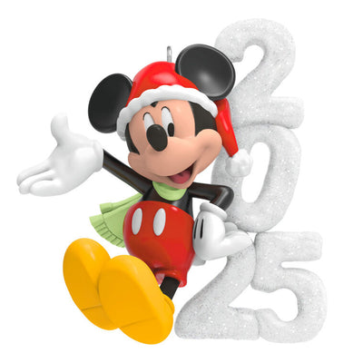 Mickey Mouse in Santa hat and scarf smiles next to a glittery “2025” snow sculpture in this festive Hallmark Keepsake Disney ornament.

