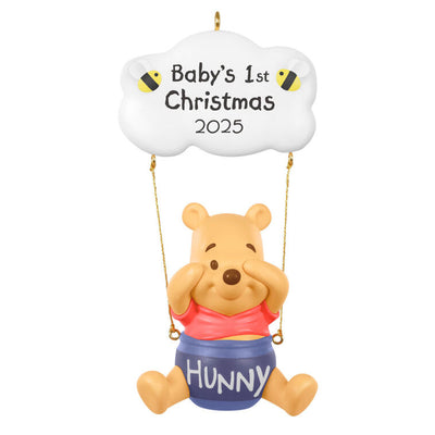 Winnie the Pooh Christmas ornament swinging under a "Baby’s 1st Christmas 2025" cloud with hunny pot and bee accents