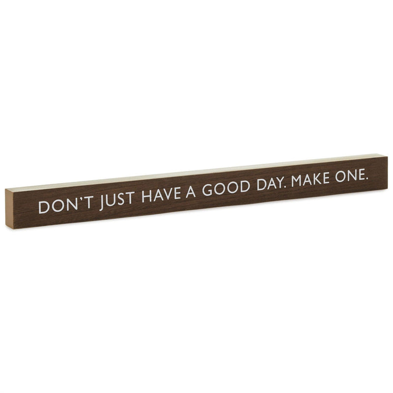 Hallmark dark wood quote sign with white lettering: Don’t just have a good day. Make one.