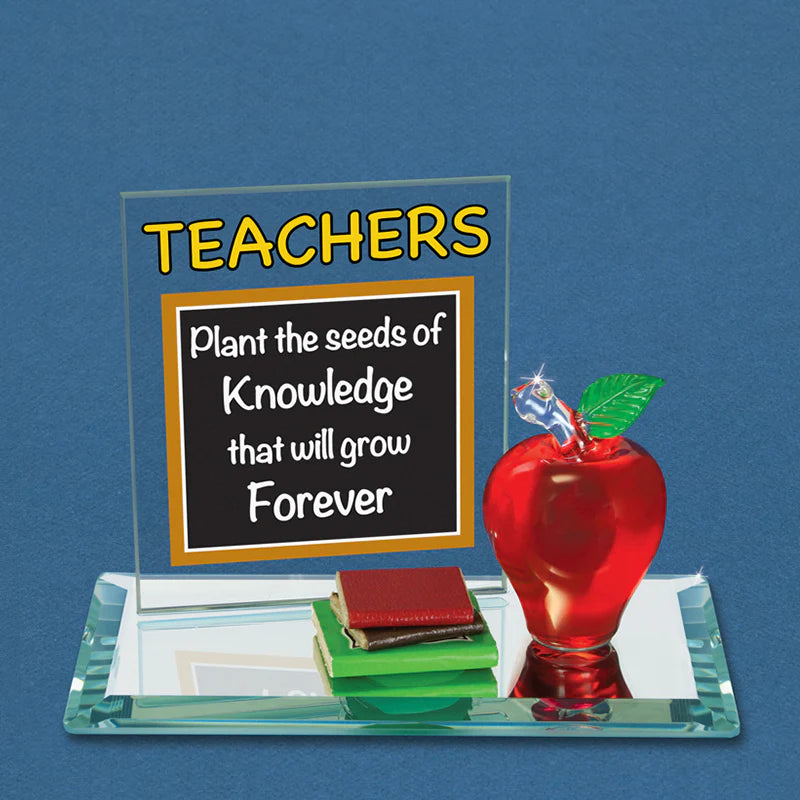 Handcrafted red glass apple figurine positioned on a mirror base with books and a sentiment back plate