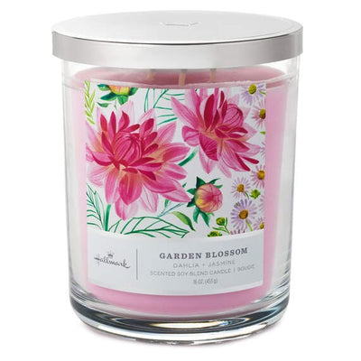 Glass jar with a pink wax seal labeled “Hallmark Garden Blossom”  filled with pink flowers and a soy blend candle. The candle wick is white.  pen_spark     tune  share   more_vert