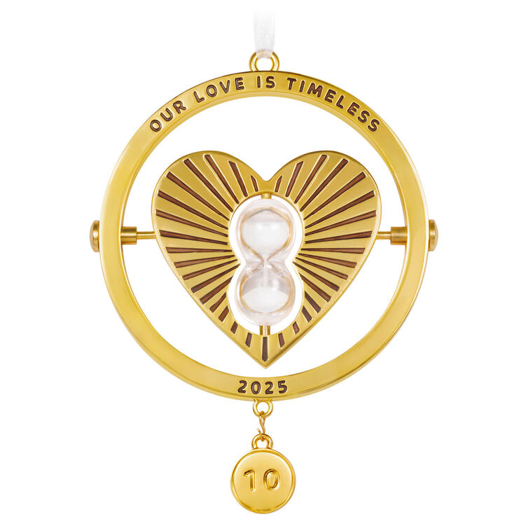 Gold metal anniversary ornament with heart and spinning hourglass, “Our Love Is Timeless” message, and interchangeable year charms.