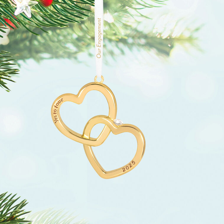 Gold interlocking heart ornament with diamond-shaped gemstone and Yes to love sentiment, 2025 engagement design.