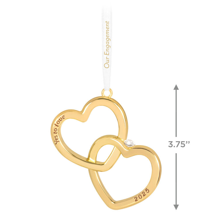 Gold interlocking heart ornament with diamond-shaped gemstone and Yes to love sentiment, 2025 engagement design.