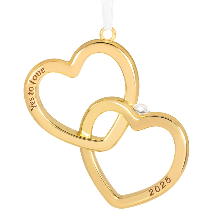 Gold interlocking heart ornament with diamond-shaped gemstone and Yes to love sentiment, 2025 engagement design.