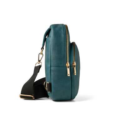 Teal Kedzie Sunset Sling Bag with gold-tone zippers, cheetah print lining, and adjustable 55” strap.

