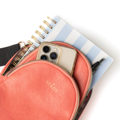 Teal Kedzie Sunset Sling Bag with gold-tone zippers, cheetah print lining, and adjustable 55” strap.

