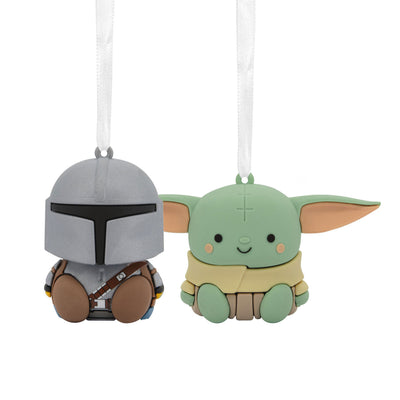 Two Star Wars Christmas ornaments featuring Grogu and a Mandalorian helmet. Grogu is a small, green alien wearing a brown robe. 
