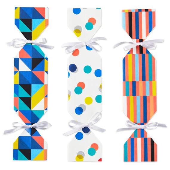 Set of 3 colorful candy-shaped party favor boxes with stripes, dots, and triangle patterns, including white satin ribbon ties
