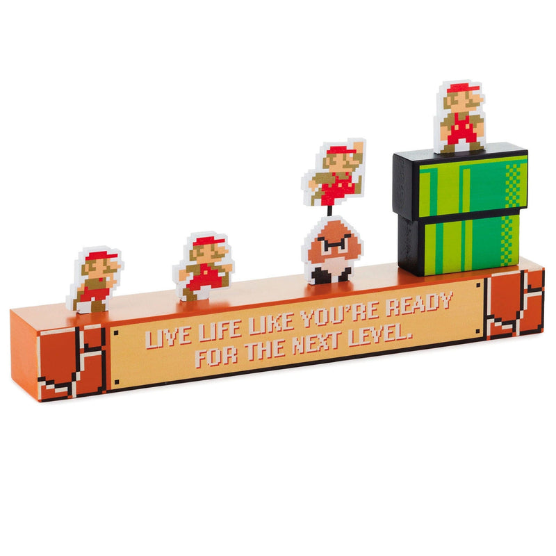 Nintendo Super Mario Bros. wooden figurine with Mario jumping over Goomba and inspirational quote.

