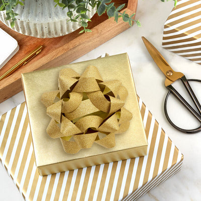 Sparkling Hallmark gold gift bow with textured ribbon and 21 loops, shown in close-up views on white background.