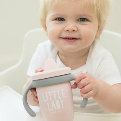 Bella Tunno Little Lady Happy Sippy Cup made of durable food-safe silicone with a soft spout, easy-grip handles, and a grow-with-me design to support your child's development.