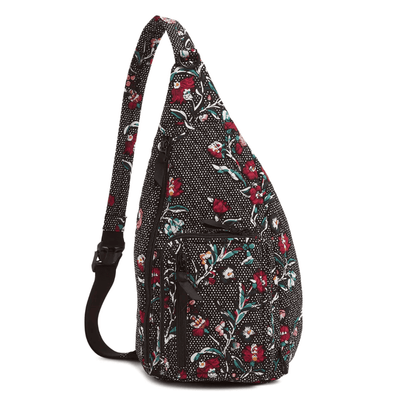 Black floral cotton sling backpack with zip pockets and adjustable strap for everyday use