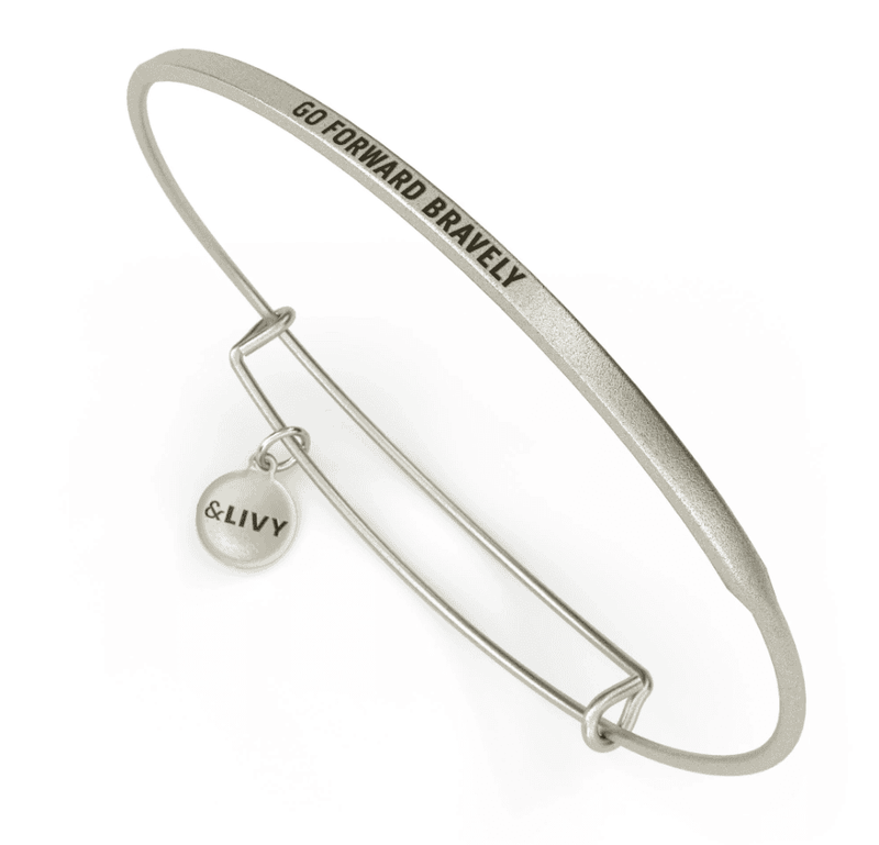 Silver bangle bracelet with a round charm featuring the message “GO FORWARD BRAVELY”. The &Livy logo is engraved on the charm.