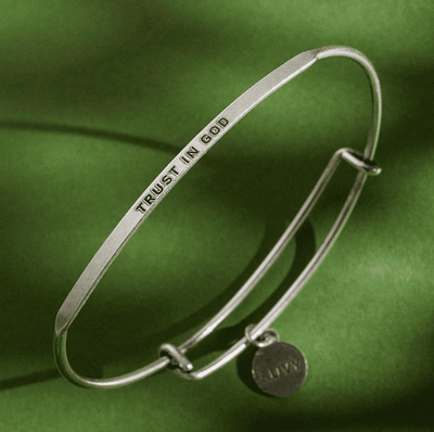 Silver bangle bracelet with the words "Trust in God" engraved on it.