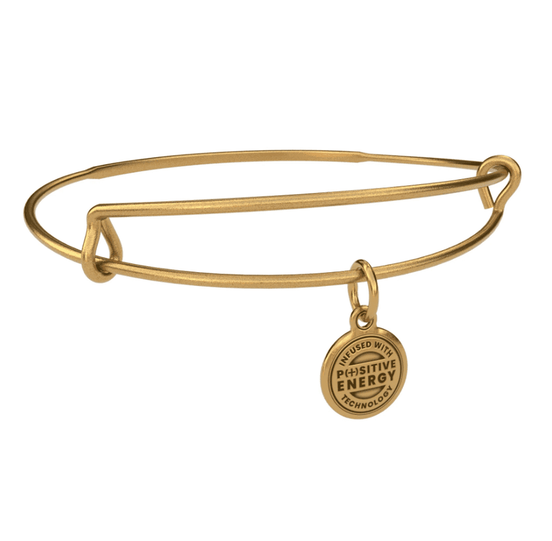 Gold bangle bracelet with a gold charm. The charm is round and features the text “ INFUSED WITH POSITIVE ENERGY TECHNOLOGY”.