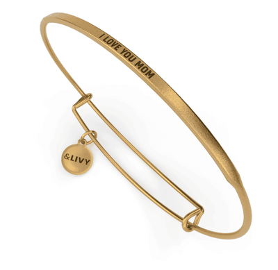 Gold bangle bracelet with a diamond-shaped charm and the word "Mom" engraved on it