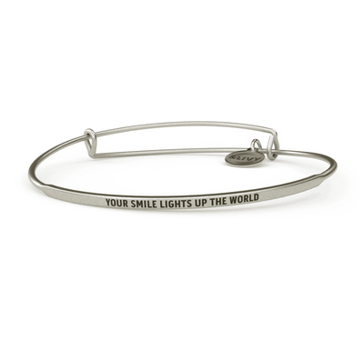 Silver bangle bracelet with "Your smile lights up the world" engraved in cursive.