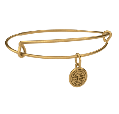 Gold bangle bracelet with a gold charm. The charm is round and features the text “INFUSED WITH POSITIVE ENERGY TECHNOLOGY”.