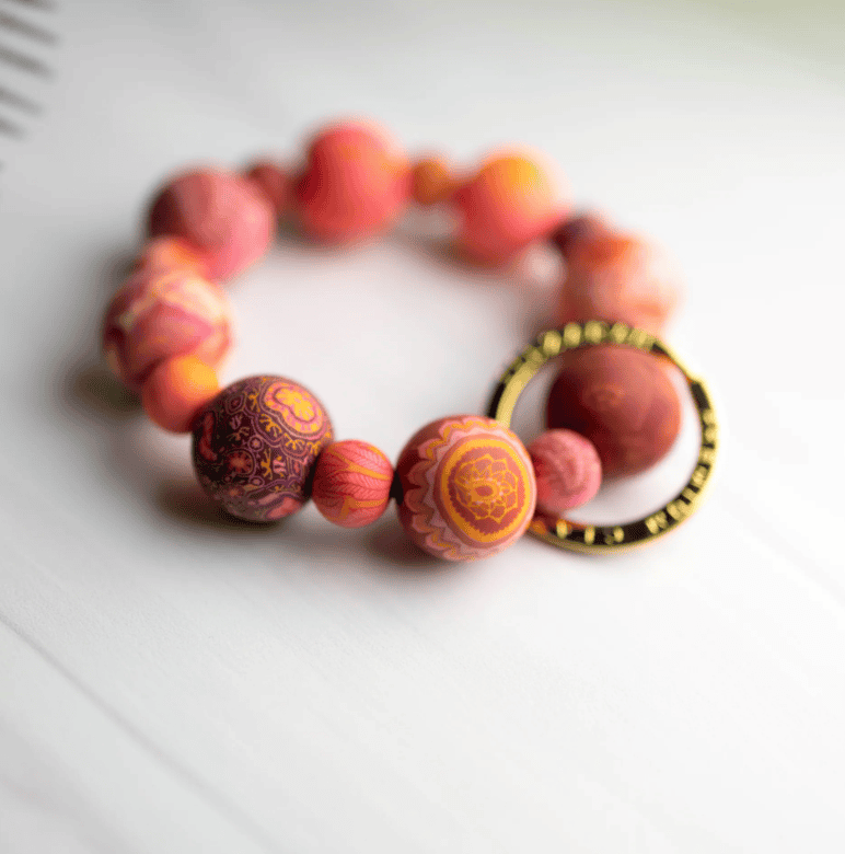 Savannah Red Wrist Keychain with handcrafted red clay beads, elastic cord, and gold key ring featuring JILZARAH logo.