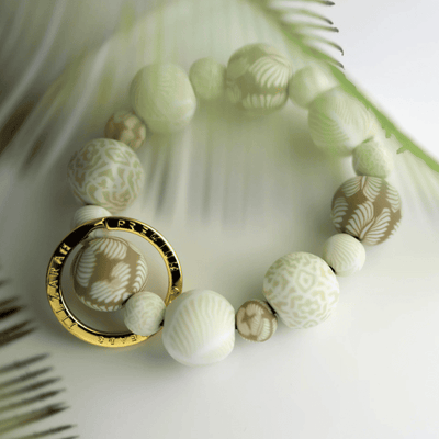Ivory Palm Wrist Keychain with handcrafted beige clay beads, elastic cord, and gold key ring featuring JILZARAH logo.